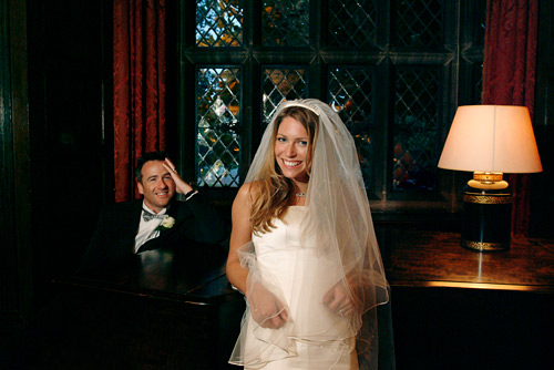 The table light on the piano was fitted with a very dim bulb. In order to render it correctly in the picture I needed to use ISO 800, 1/10th second at f/4. I used a splash of flash from the left to light the bride and groom.