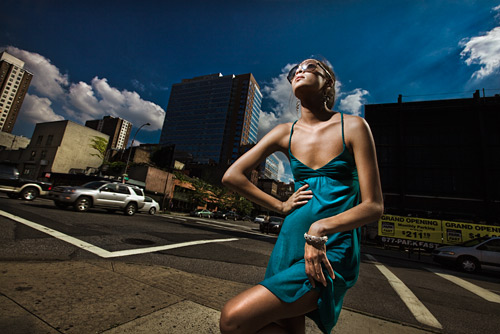 The sun was our back light and a Speedlight was our key. f/16 was needed for this shot. It is the same techniquy as Louis Vuiton use in their advertising campaigns. Only they use soft boxes and Broncolor Mobil lighting no doubt.