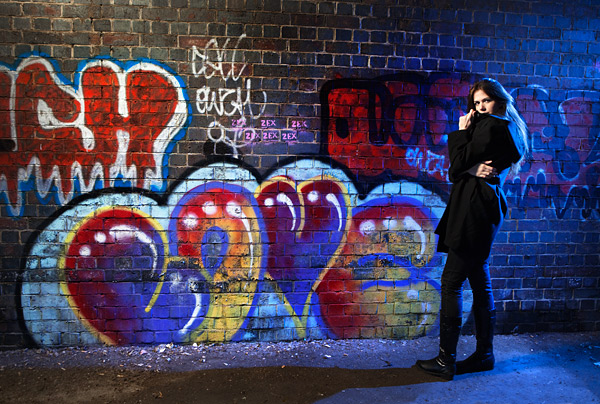 This night street scene was shot in daylight at my latest secret location. I used two Speedlights, some Honl gels and a Lastolite Ezybox to make the picture.