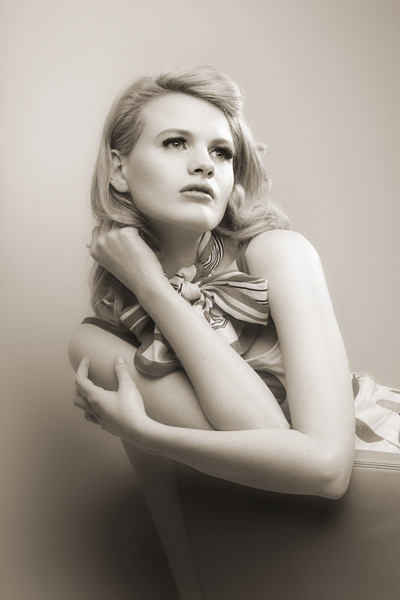 100mm lens at f/11 One soft box as a keylight and one standard reflector with a honeycomb grid used as a kick light was the lighting set up. I just sat Chloe in a chair and positioned her arms to create the strong diagonal composition. A very low viewpoint and Chloe’s far away gaze complete the picture.